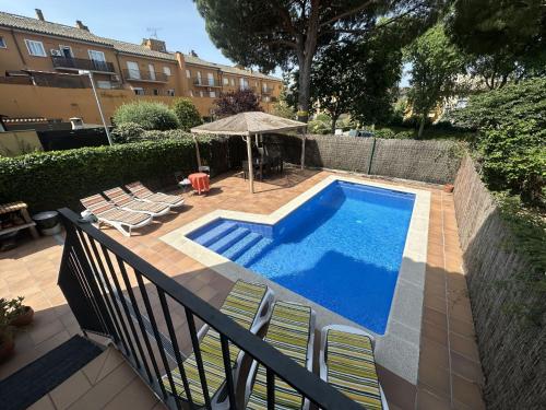 a swimming pool with chairs and an umbrella next to a building at Holiday Home La Victoria by Interhome in Palafrugell