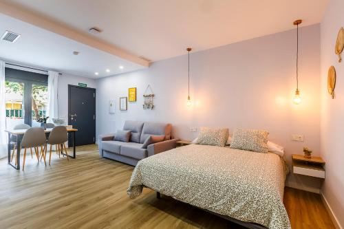 a bedroom with a bed and a couch and a table at Apartamentos Baviera Dreams in Torre del Mar
