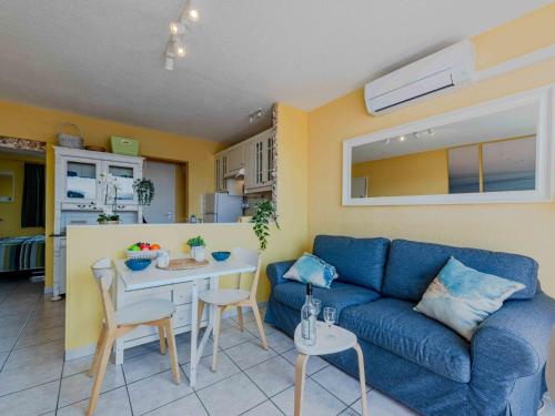 un salon avec un canapé bleu et une table dans l'établissement Apartment Palmyra-3 by Interhome, au Barcarès
