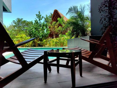 a patio with a table and chairs and a pool at Paramar Black Condominio en Tulum in Tulum