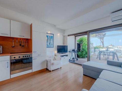 une cuisine et un salon avec un canapé et une télévision dans l'établissement Apartment Palmyra-8 by Interhome, au Barcarès