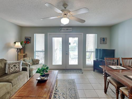a living room with a couch and a ceiling fan at Grand Caribbean Perdido Key #306 West in Perdido Key