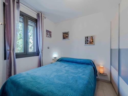 une chambre avec un lit bleu et une fenêtre dans l'établissement Apartment Coudalère - Jamaica-2 by Interhome, au Barcarès
