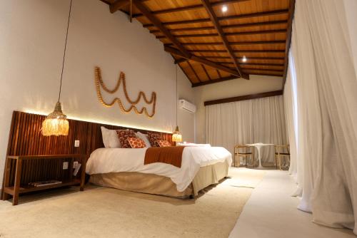 a bedroom with a bed with a sign on the wall at Casa dos Corais Patacho in Pôrto de Pedras