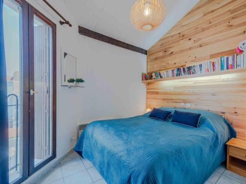 une chambre avec un lit bleu avec un mur en bois dans l'établissement Apartment Dominica-3 by Interhome, au Barcarès