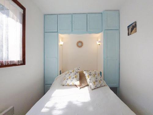 - un lit avec une tête de lit bleue et 2 oreillers dans l'établissement Apartment Jardins de la Palmyre 2-1 by Interhome, à La Palmyre