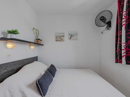 une petite chambre avec un lit blanc et un mur blanc dans l'établissement Apartment Les Marquises-5 by Interhome, au Barcarès