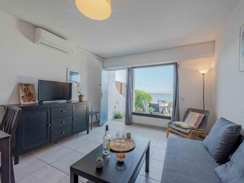 un salon avec un canapé et une télévision dans l'établissement Apartment Coudalère-Guadeloupe-9 by Interhome, au Barcarès