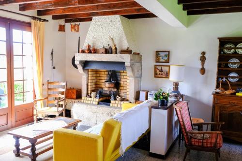 - un salon avec une cheminée en pierre et des chaises jaunes dans l'établissement L'Air du Temps - Campagne, Calme, Familial, à Lapte