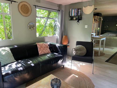 BeyssacにあるUn bel endroit dans la natureのリビングルーム(黒い革張りのソファ、テーブル付)