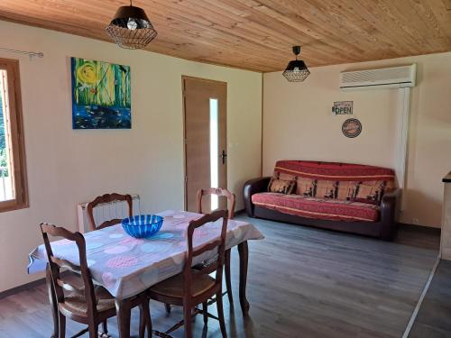 a room with a table and chairs and a bed at Gîte des giblins - Saint Amand en Puisaye in Saint-Amand-en-Puisaye
