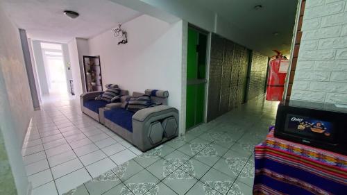 a living room with a couch and a tv at Hospedaje El Paraiso in Santa Eulalia