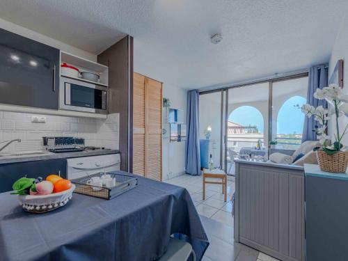 une cuisine avec une table avec un bol de fruits dessus dans l'établissement Apartment Caraibes-1 by Interhome, au Barcarès