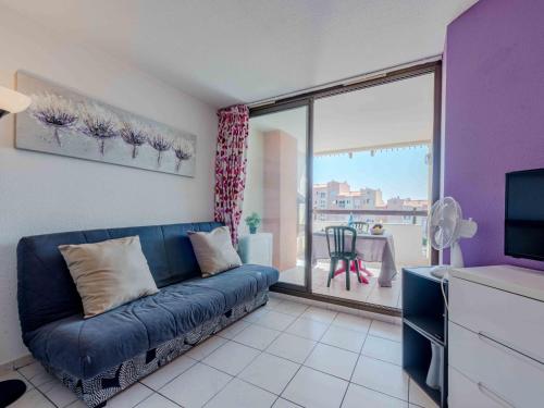 un salon avec un canapé bleu devant une fenêtre dans l'établissement Apartment Barbados-2 by Interhome, au Barcarès