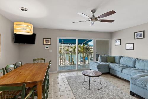 a living room with a blue couch and a table at Dolphin Cove- Pet Friendly Waterfront Townhome w Pool in Marathon
