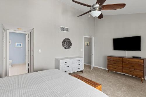 a bedroom with a bed and a flat screen tv at Dolphin Cove- Pet Friendly Waterfront Townhome w Pool in Marathon