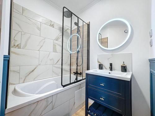 une salle de bain avec une baignoire, un lavabo et un miroir dans l'établissement L'Azuro - jardin privé, à Troyes