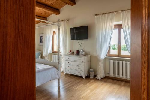 a bedroom with a white dresser and a television at B&B La Casa del Gallese in Sorbolongo