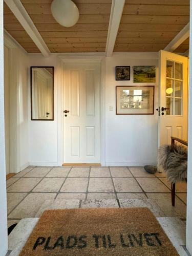 a room with a white door and a rug at Historic Thatched House From 1750 In Husby in Ulfborg