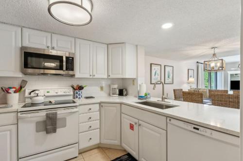 a white kitchen with a sink and a microwave at 2034 Beachwood in Fernandina Beach
