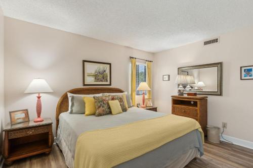 a bedroom with a bed and two lamps and a mirror at 2034 Beachwood in Fernandina Beach