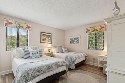 two beds in a room with two windows at 2034 Beachwood in Fernandina Beach