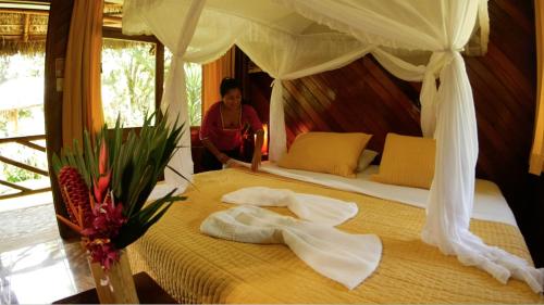 a woman in a room with a bed with towels at Shandia Lodge in Tena
