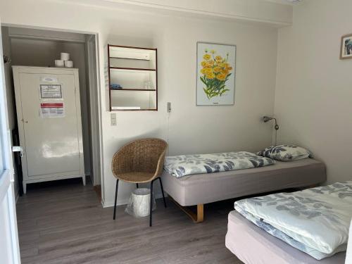 a bedroom with two beds and a chair in it at Hohenwarte in Højer