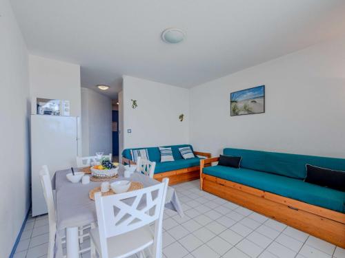 un salon avec un canapé bleu et une table dans l'établissement Apartment Coudalère - Jamaica-4 by Interhome, au Barcarès