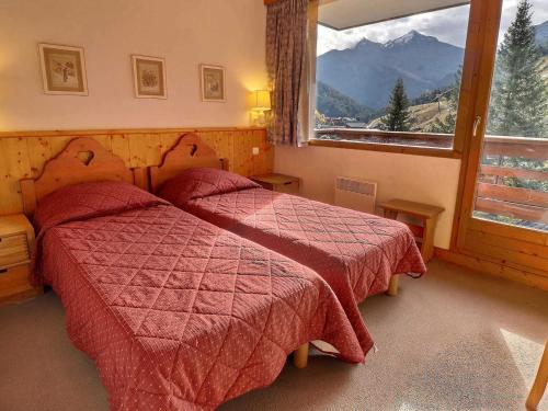une chambre avec deux lits et une grande fenêtre dans l'établissement Appartement Clair et Cosy, Sur les Pistes, Balcon Sud, Proche Commerces, 3* pour 4 Personnes - FR-1-182-13, à Méribel
