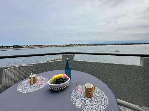 - une table avec un bol de fruits et une bouteille dans l'établissement Apartment Les Marquises-6 by Interhome, au Barcarès