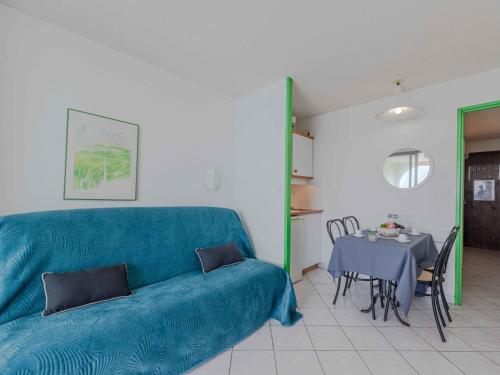 un salon avec un canapé bleu et une table dans l'établissement Apartment Les Marquises-7 by Interhome, au Barcarès