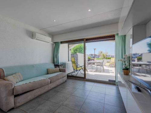 un salon avec un canapé et une terrasse dans l'établissement Apartment Palmyra-9 by Interhome, au Barcarès