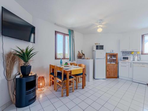 Il comprend une cuisine et une salle à manger avec une table et une télévision. dans l'établissement Apartment Dominica-5 by Interhome, au Barcarès