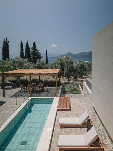 a swimming pool with a table and a gazebo at Nima Residences in Paleros