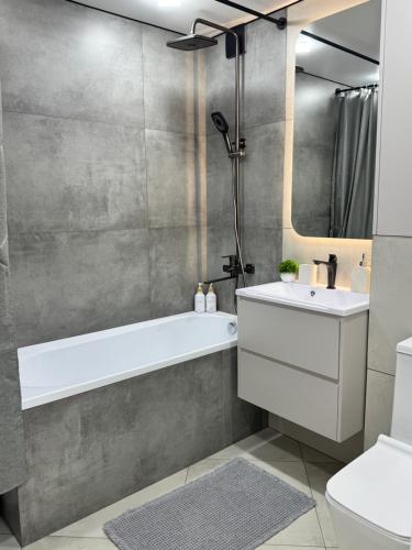 a bathroom with a white tub and a sink at Квартира 2-комнатная in Balqash