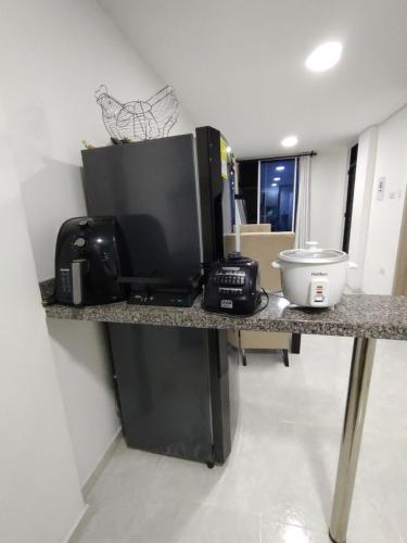 a kitchen counter with a microwave and a television on it at Confortable y Fresco Apartamento Girón in Girón