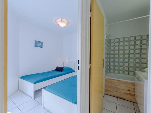 une salle de bain avec deux lits et une baignoire et une douche dans l'établissement Apartment Dominica-7 by Interhome, au Barcarès