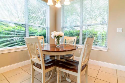 a dining room table with chairs and a vase of flowers at You're On Island Time in this 4 BR in Quiet Neighb in Sampson