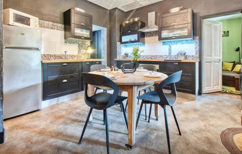 une cuisine avec une table et des chaises en bois dans l'établissement Cozy Home In Les Eyzies, à Les Eyzies-de-Tayac