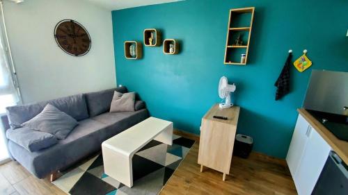 un salon avec un canapé et une horloge au mur dans l'établissement studio agréable à 2 pas du centre ville, à Vannes