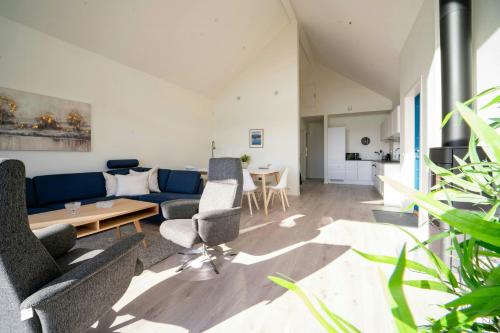a living room with a blue couch and chairs at Modern Holiday Home With Sea View In Borhaug in Borhaug