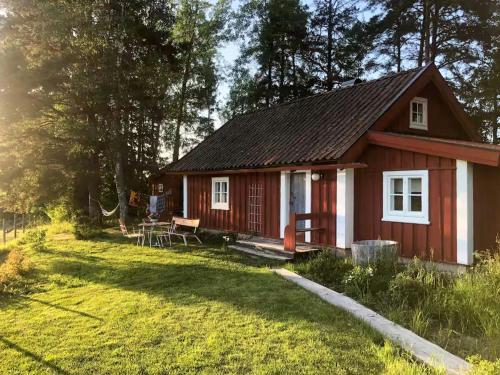 a red cottage with a picnic table in a yard at Country Cottage By Natural Pond In Söderköping in Gusum