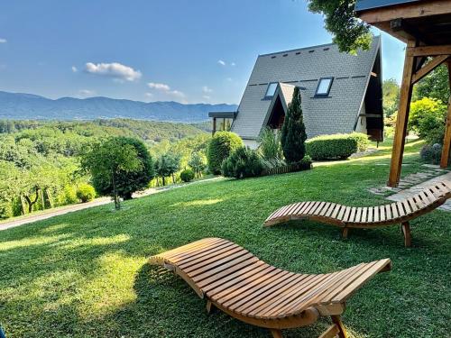 two benches sitting in the grass in front of a house at Kuća za odmor Bitoševje in Klenovnik