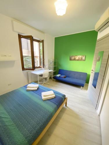 a bedroom with a blue bed and a green wall at Birsa's Rooms in Cagliari