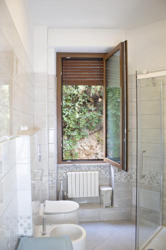 a bathroom with a toilet and a window at Birsa's Rooms in Cagliari