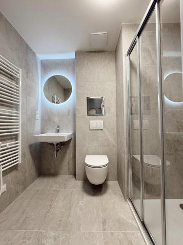 Un baño con inodoro, lavabo y ducha. en SuperNova Apartments, en Brno