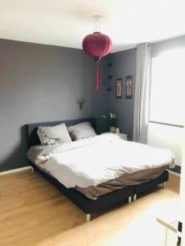 a bedroom with a large bed with a red chandelier at Gezellig, volledig ingericht huis in Nijmegen in Nijmegen