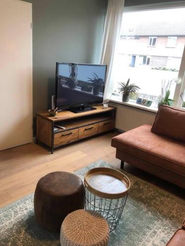 a living room with a flat screen tv and a couch at Gezellig, volledig ingericht huis in Nijmegen in Nijmegen