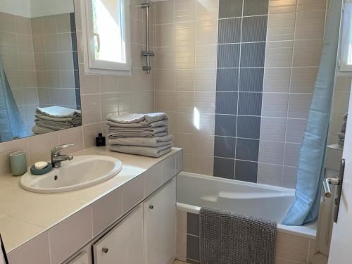 a bathroom with a sink and a mirror and a tub at Maison village provençal in Éguilles